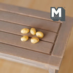 1:12 scale miniature potatoes with speckled yellow skins, set of 5, shown on a gray wood table