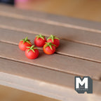 1:12 scale miniature red tomatoes with green stems, set of 5, shown on a wood slat table