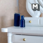 1:12 scale miniature navy blue perfume bottle and box, set of 2, shown on a white vanity table
