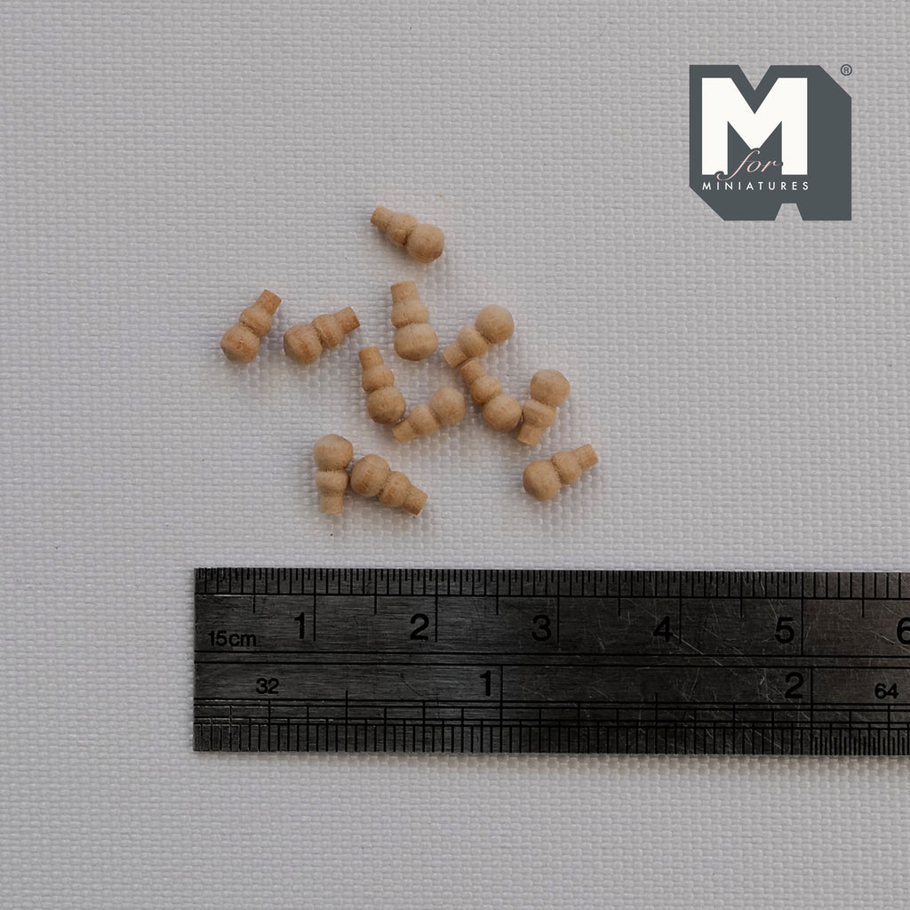 1:12 scale miniature unpainted wood door knobs, set of 12, shown scattered above a ruler for scale