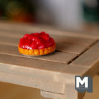 1:12 scale miniature strawberry pie on metal plate, glossy red strawberries on a golden crust, on a wood table