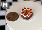 1:12 scale miniature clay chocolate cake with cherries and cream rosettes, shown on a white table beside a coin