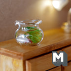 1:12 scale miniature glass fish bowl with fish and green water plants and a ruffled rim, shown on a wood dresser