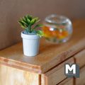 1:12 scale miniature cast resin potted agave succulent in a white round pot, green leaves, on a wood cabinet by a fish bowl