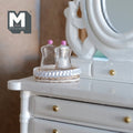 1:12 scale miniature oval rope basket with 2 clear bottles with pink tops, set of 3, shown on a white vanity