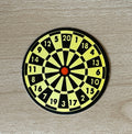 1:12 scale miniature cardstock dartboard in black and yellow with numbers and red bullseye, board only, on a wood surface