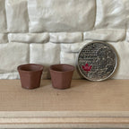 1:12 scale miniature clay hexagon flower pots in brown, set of 2, shown on a wood shelf beside a coin for scale