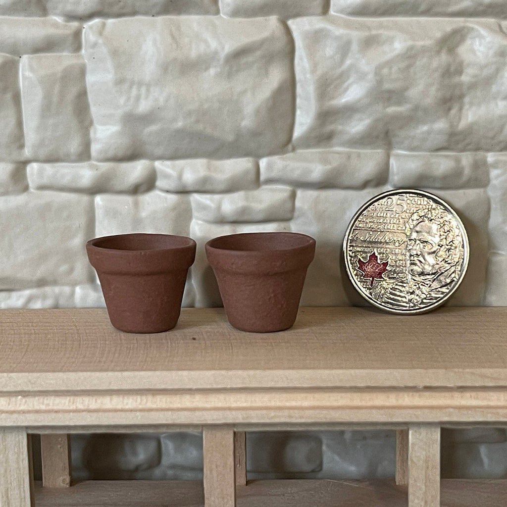 1:12 scale miniature clay flower pots in brown terracotta, set of 2, on a wood shelf beside a coin for scale