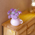 1:12 scale miniature lilac flowers in a pink pitcher vase with purple blooms, shown on a wood dresser