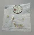 1:12 scale miniature brass house numbers 0 to 9 in gold, set of 10, loose digits shown in a clear bag beside a coin