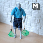 1:12 scale miniature fishing nets in green with wood handles, set of 2, shown held by an artist figure