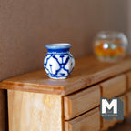 1:12 scale miniature ceramic hexagon vase with blue and white pattern, shown on a wood dresser