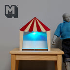 1:12 scale miniature wood circus tent display box with LED light, red and cream striped roof, shown lit on a wood table