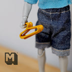 1:12 scale miniature metal clothes hangers in yellow, set of 6, shown held in the hand of a poseable figure