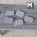 1:12 scale miniature metal baking molds in silver, bear, panda, paw, tart and shell shapes, set of 5, on a gray wood table