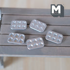 1:12 scale miniature metal baking molds in silver, bear, panda, paw, tart and shell shapes, set of 5, on a gray wood table