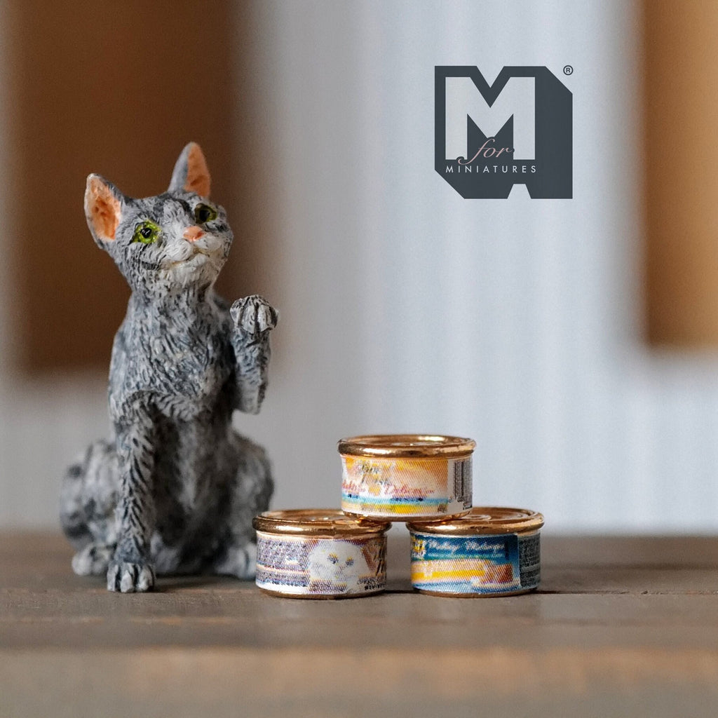 1:12 scale miniature metal cat food cans with lids, set of 3, printed labels, stacked beside a gray tabby cat figure