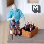 1:12 scale miniature brown wood wine crate with 12 assorted wine bottles, red and rose, shown with a poseable figure