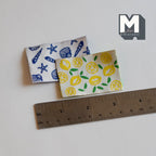 1:12 scale miniature tea towels with blue seashell and yellow lemon prints, set of 2, shown with a ruler