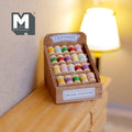 1:12 scale miniature wood spool stand filled with colorful sewing thread spools, displayed on a wood cabinet near a lamp