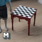 1:12 scale miniature wood checkerboard table in burgundy with black and white square top, shown beside a poseable figure