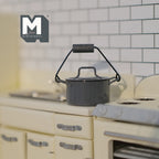 1:12 scale miniature metal slop bucket with lid and handle in dark gray, shown on a cream kitchen counter