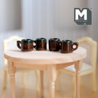 1:12 scale miniature stoneware mugs in dark brown with green glazed rims, set of 4, shown on a round wood table