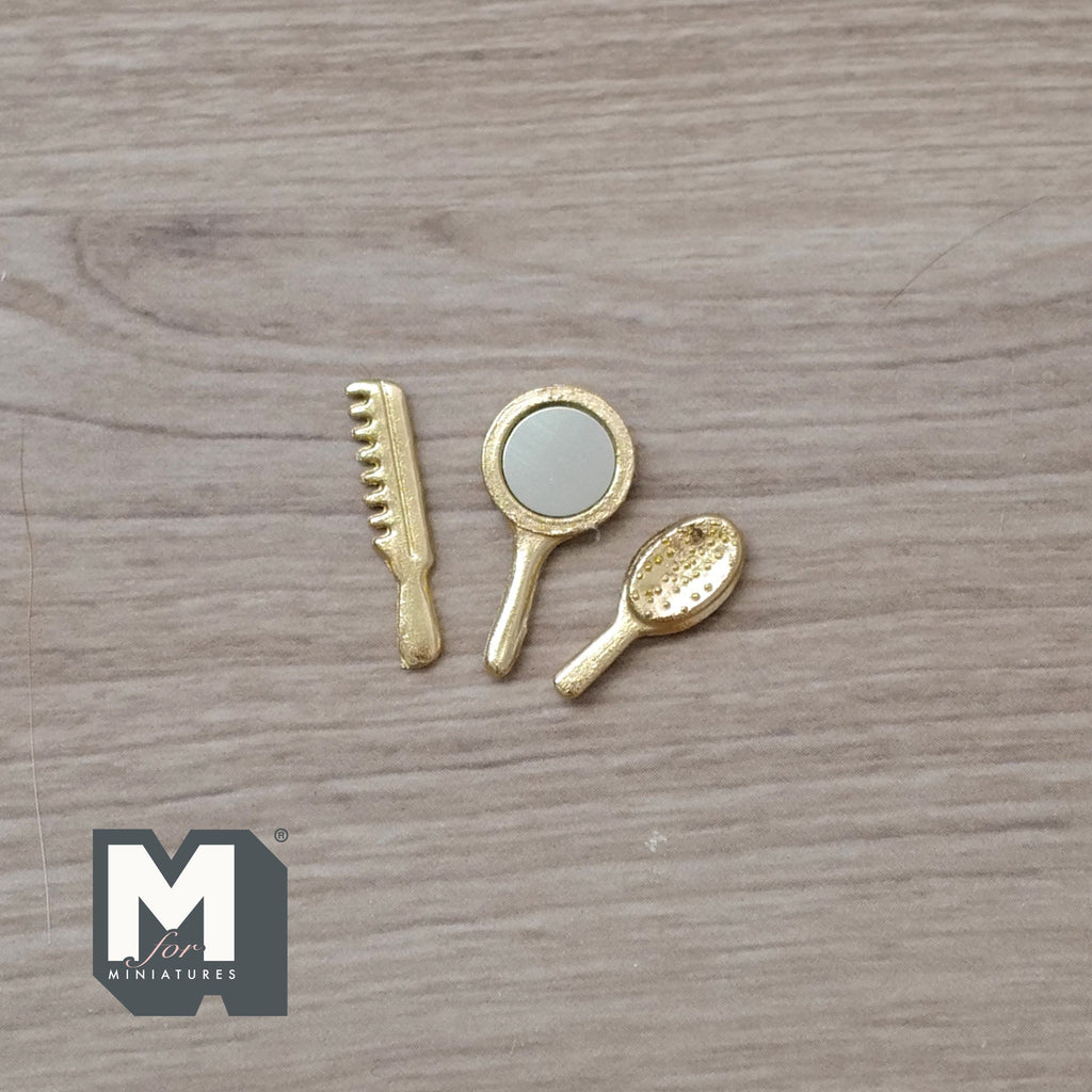 1:12 scale miniature gold hand mirror, comb and hair brush, set of 3, laid out on a wood surface
