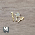 1:12 scale miniature gold hand mirror, comb and hair brush, set of 3, laid out on a wood surface