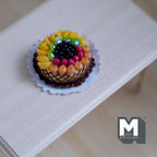 1:12 scale miniature fruit tart cake, large, topped with peach, cherries and blueberries, shown on a white table