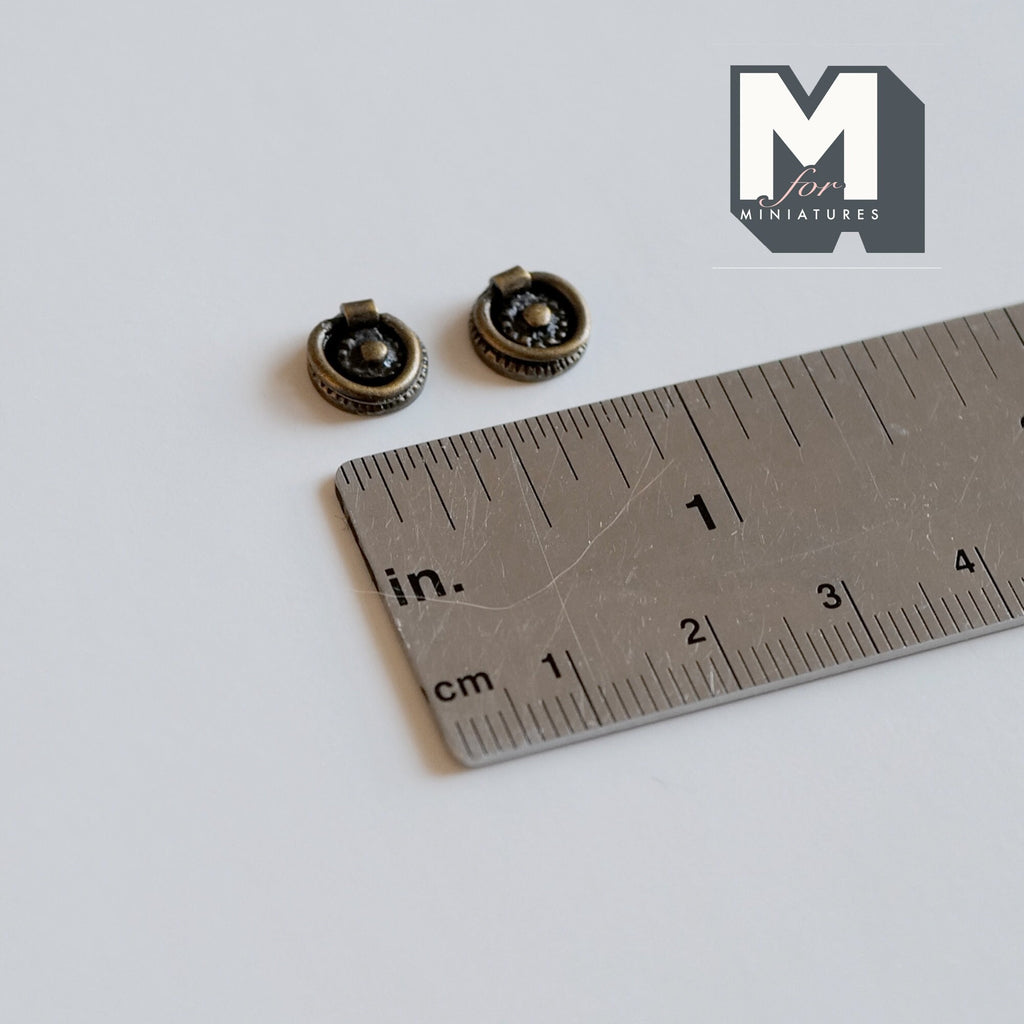1:12 scale miniature antique brass ring drawer pulls with round backplates, set of 2, shown with a ruler