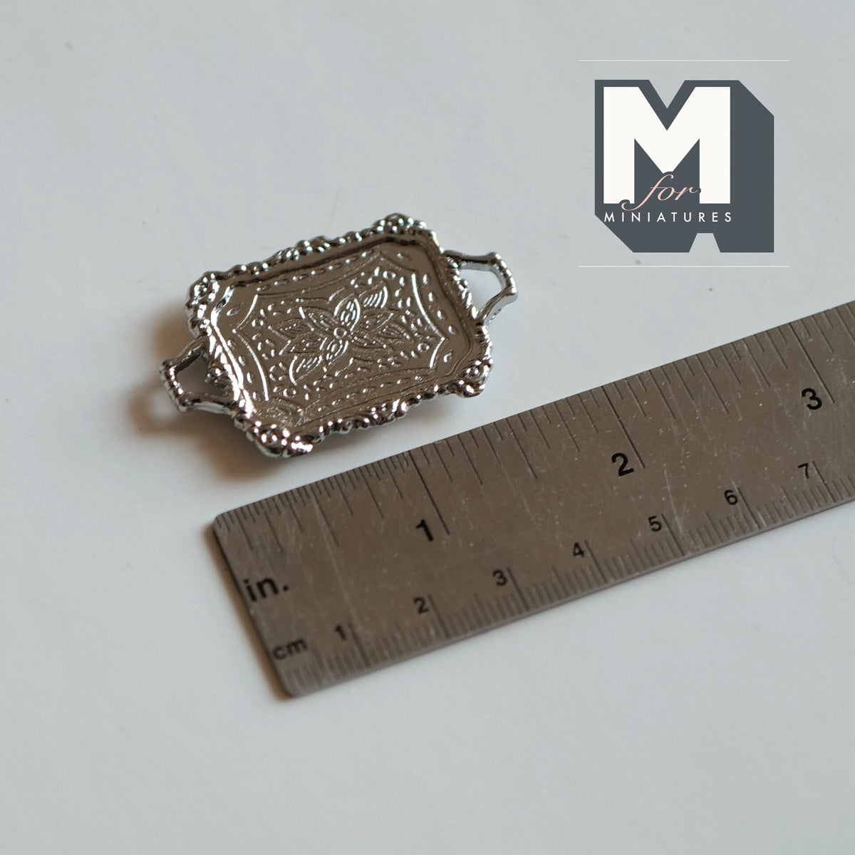 1:12 scale miniature metal engraved serving tray in silver with handles and scalloped rim, shown with a ruler