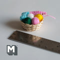1:12 scale miniature woven knitting basket with yarn balls in green, yellow, pink and white, shown with a ruler