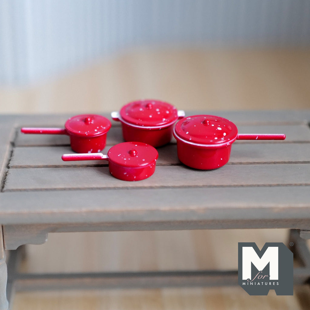 1:12 scale miniature red metal cooking pots in speckled enamel style, set of 4 with lids and handles, on a gray table