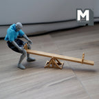 1:12 scale miniature wood seesaw with A frame pivot, natural finish, shown with a figure for scale