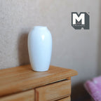 1:12 scale miniature white ceramic tall vase with narrow neck and glossy glaze, shown on a wood dresser