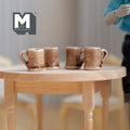 1:12 scale miniature ceramic beer mugs in mottled brown and cream glaze, set of 4, shown on a round wood table