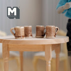 1:12 scale miniature ceramic beer mugs in mottled brown and cream glaze, set of 4, shown on a round wood table