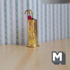 1:12 scale miniature metal umbrella stand in gold with 2 closed umbrellas, shown on a wood floor by striped wallpaper