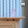 1:12 scale miniature glass vase with flared rim in pink, translucent ribbed body, shown on a wood mantel