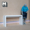 1:12 scale miniature console table in white with slab legs, shown against a wall beside a jointed figure for scale