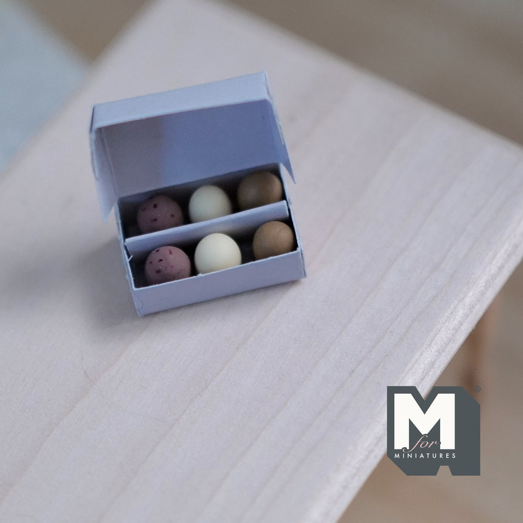 1:12 scale miniature egg carton with 6 brown and white eggs, non edible, gray box shown open on a wood table