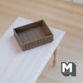 1:12 scale miniature rectangular woven basket in brown with low open sides, shown on a white table
