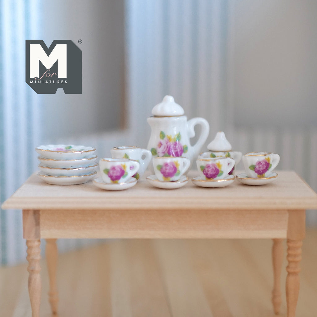 1:12 scale miniature porcelain tea set with pink flowers and green leaves, set of 15, shown on a wood table