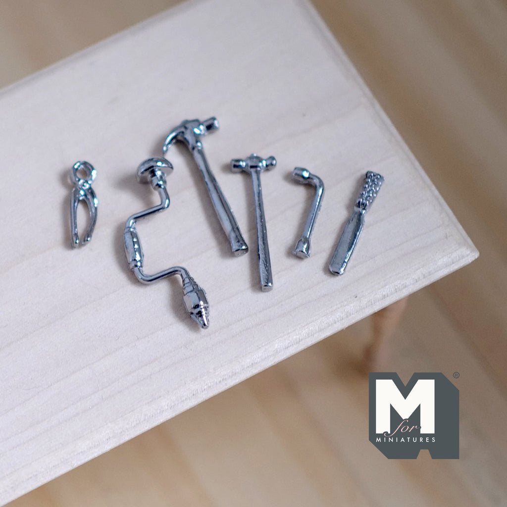 1:12 scale miniature metal hand tools, hammers, pincers and bit brace, set of 6, silver tone, laid out on a wood table