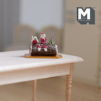 1:12 scale miniature Christmas yule log roll cake with red berries and Santa topper, on a board on a wood table