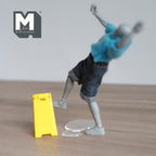 1:12 scale miniature wet floor sign in yellow with clear water puddle, set of 2, shown with a slipping artist figure