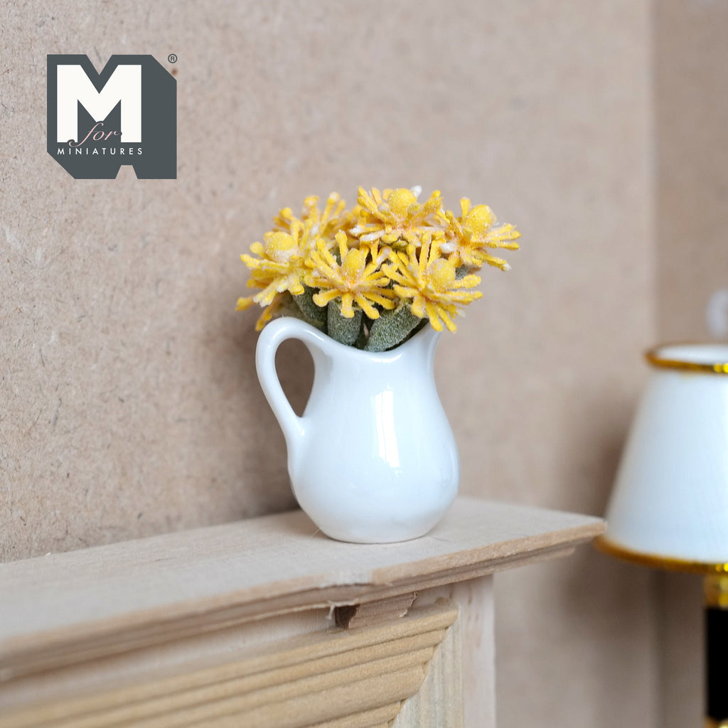1:12 scale miniature yellow flowers in a white ceramic pitcher vase, daisy style blooms, shown on a wood mantel shelf