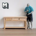 1:12 scale miniature unpainted wood foyer table with 3 drawers, turned legs and lower shelf, beside an artist figure