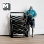 1:12 scale miniature black metal newspaper stand with perforated tiered racks, shown beside an artist figure